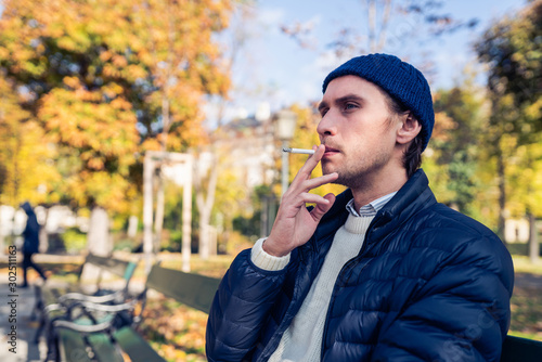 Young man on a bench with a cigarette