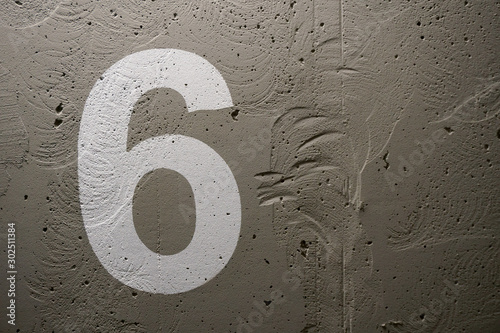 The number 6 painted stencil on a concrete wall