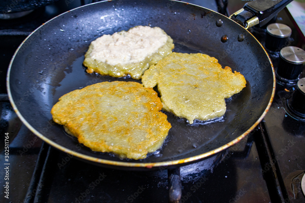 cooking potato pancakes in a pan, boiling oil cooking potato pancakes in a pan, boiling oil