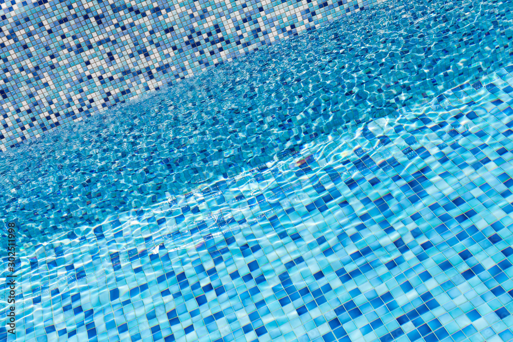 Empty pool, blue water and mosaic tiling
