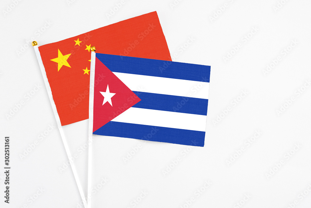 Cuba and China stick flags on white background. High quality fabric, miniature national flag. Peaceful global concept.White floor for copy space. Cuba and China stick flags on white background. High quality fabric, miniature national flag. Peaceful global concept.White floor for copy space.