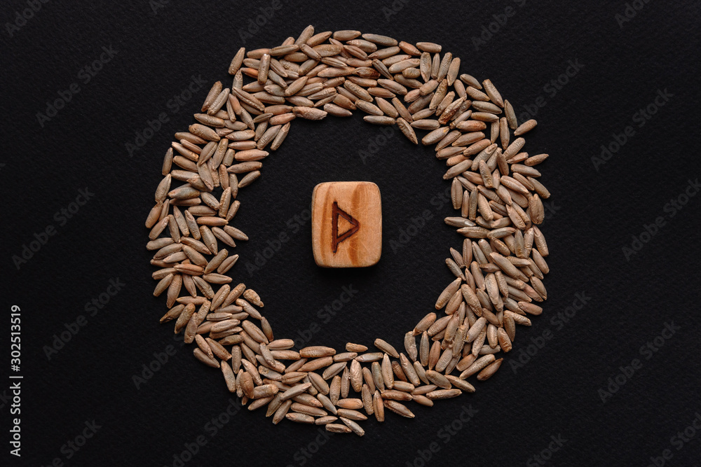 Thurisaz Rune Rounded wooden Thurisaz rune on black background in rye circle, scandinavian ...