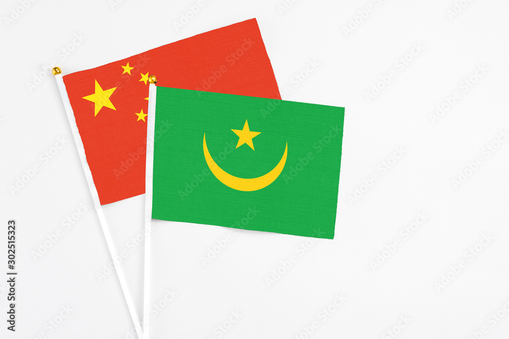 Mauritania and China stick flags on white background. High quality fabric, miniature national flag. Peaceful global concept.White floor for copy space. Mauritania and China stick flags on white background. High quality fabric, miniature national flag. Peaceful global concept.White floor for copy space.