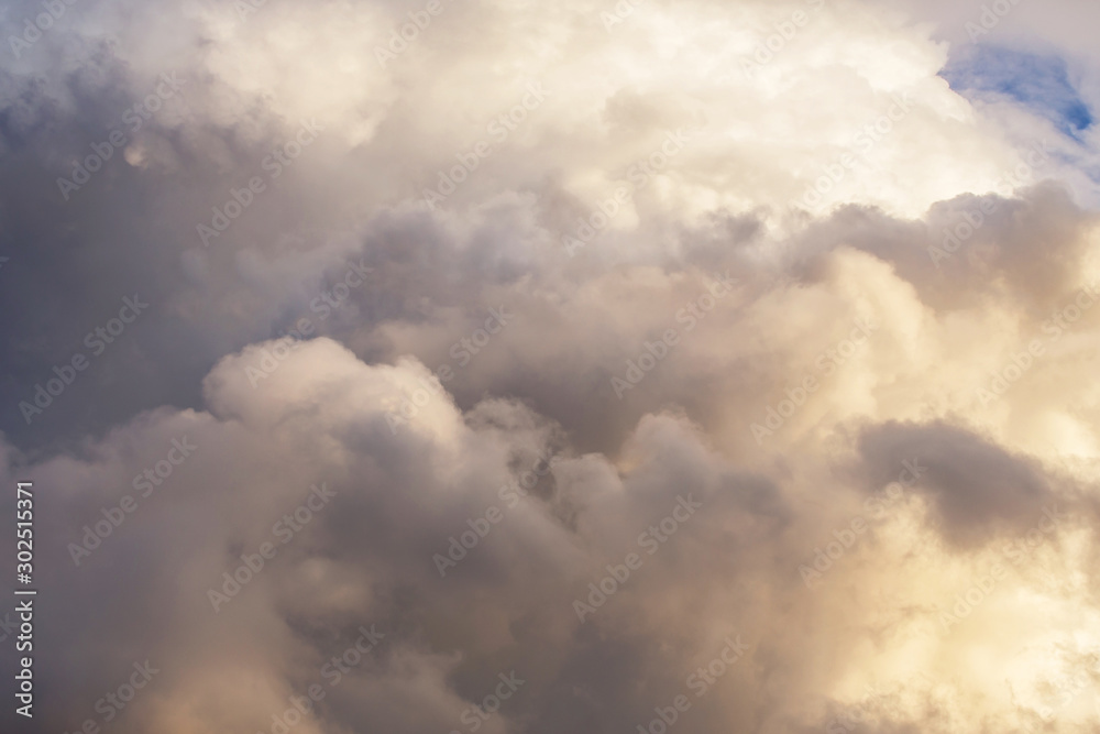 Dramatic cumulus fluffy clouds in sunlight texture background