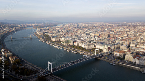 The highest point of Budapest with a view of the city panorama. A river with bridges and ships. Sunset sun. Chain bridge, palace and parliament. Top view.