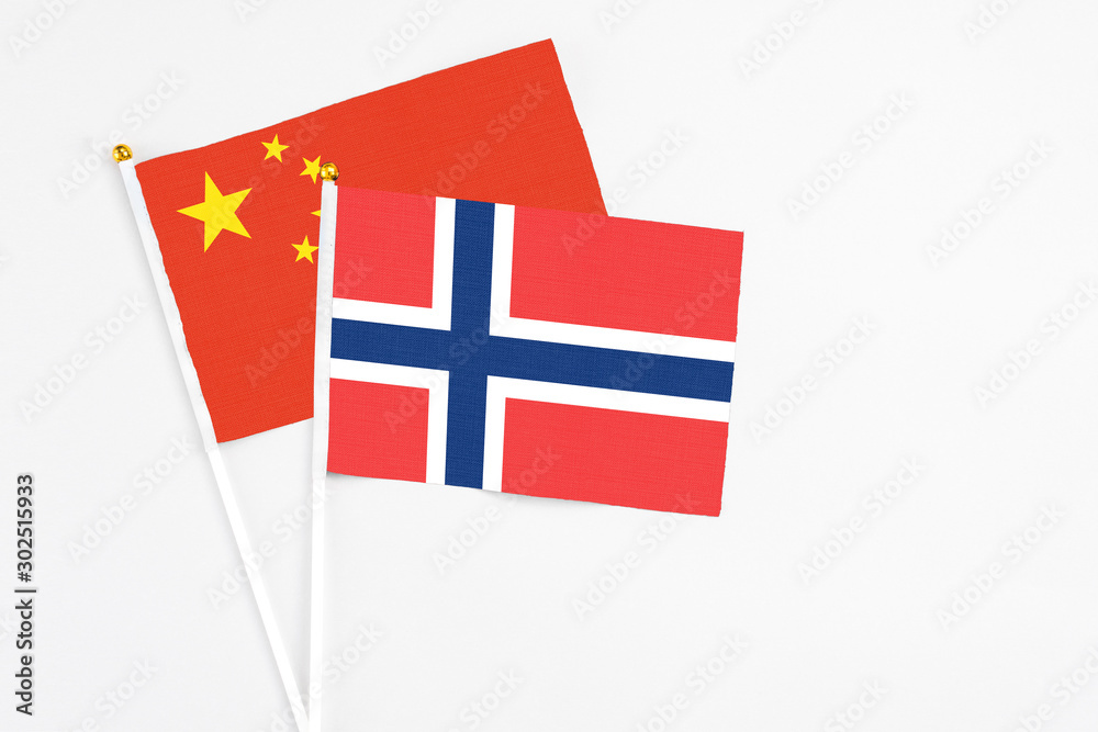 Norway and China stick flags on white background. High quality fabric, miniature national flag. Peaceful global concept.White floor for copy space.