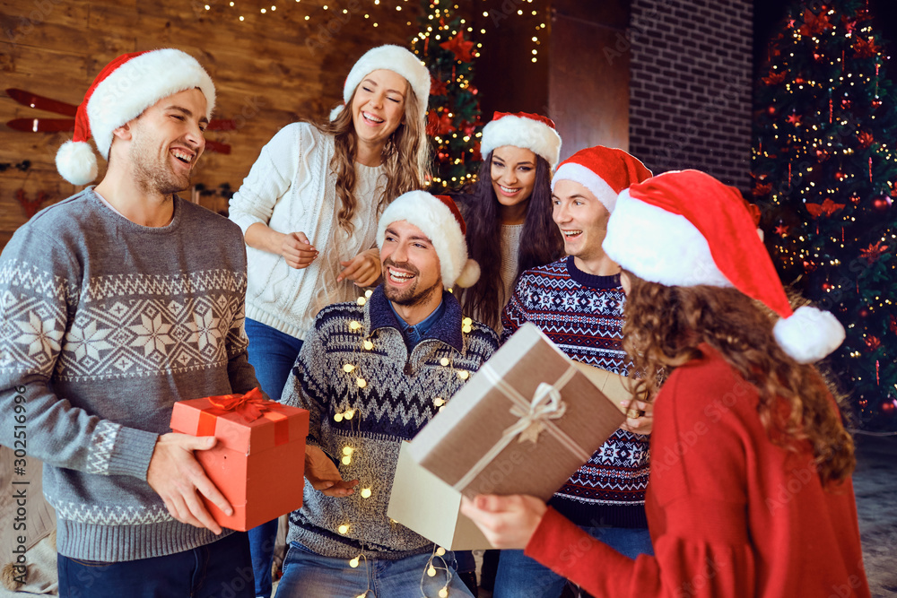 Happy friends with gifts celebrating Christmas - obrazy, fototapety, plakaty 