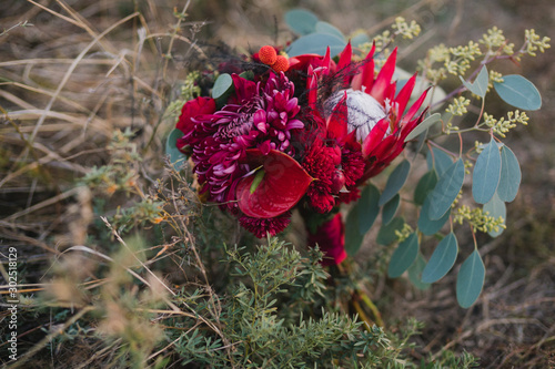 Beautiful modern bridal bouquet of colorful fresh flowers with sikl ribbons. Classic wedding traditional accessory. photo