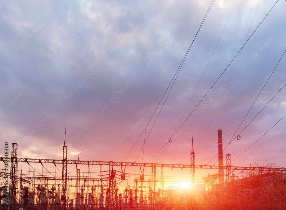 High-voltage power lines at sunset or sunrise. High voltage electric transmission tower