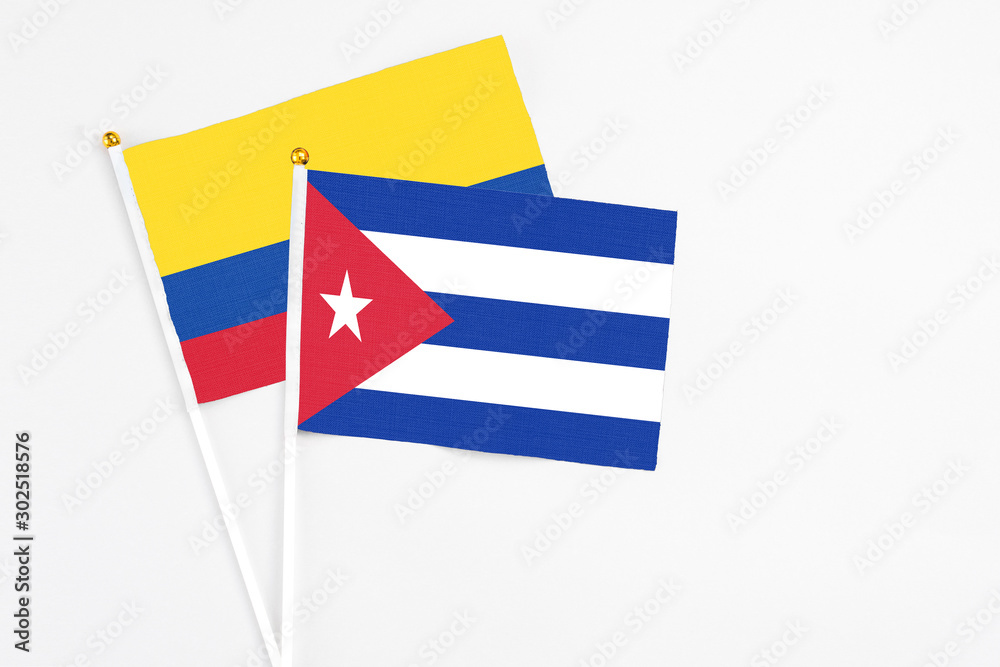 Cuba and Colombia stick flags on white background. High quality fabric, miniature national flag. Peaceful global concept.White floor for copy space.