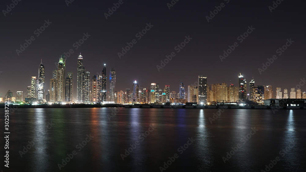 Dubai skyline at night with lights reflections on the Gulf 