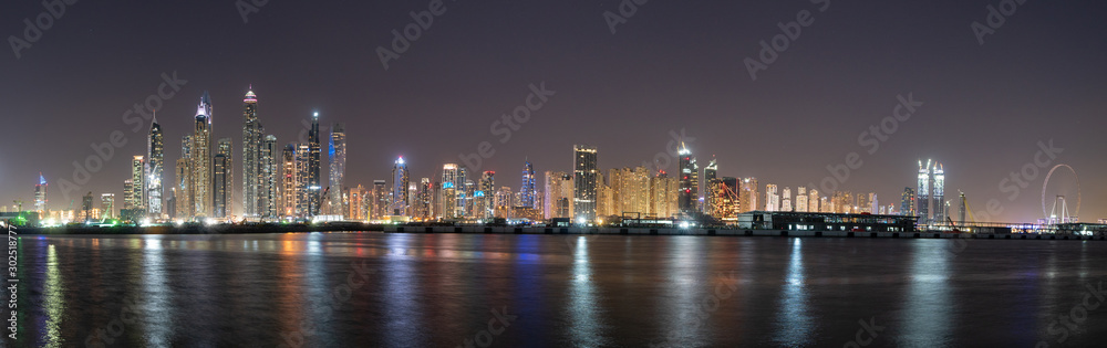 Dubai skyline panorama at night showing skyscrapers and new constructions and lights on the water