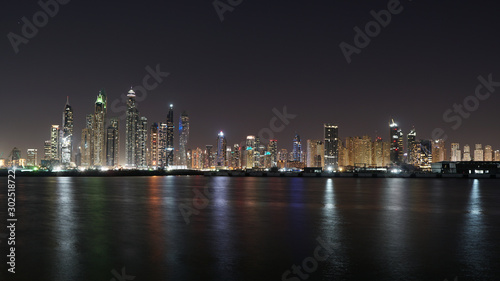 Dubai skyline at night with lights reflections on the Gulf 