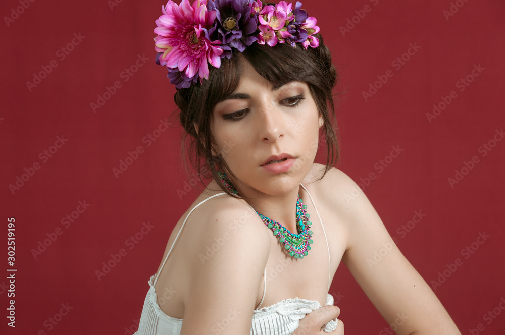 Young woman dancing with white dress and flowers in her hair. Red background. Young woman dancing with white dress and flowers in her hair. Red background.