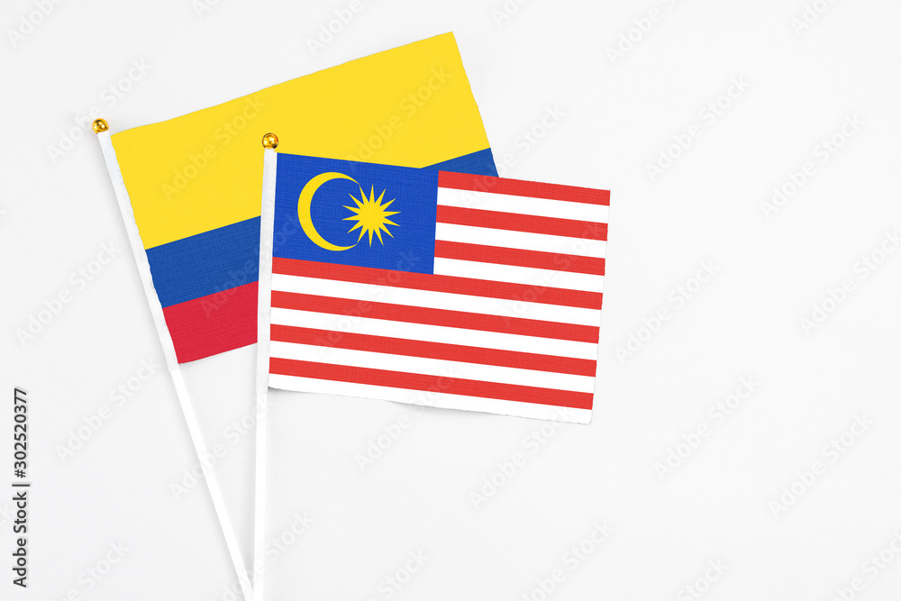 Malaysia and Colombia stick flags on white background. High quality fabric, miniature national flag. Peaceful global concept.White floor for copy space. Malaysia and Colombia stick flags on white background. High quality fabric, miniature national flag. Peaceful global concept.White floor for copy space.