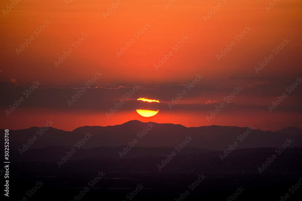 the reddish sun behind the mountains the reddish sun behind the mountains