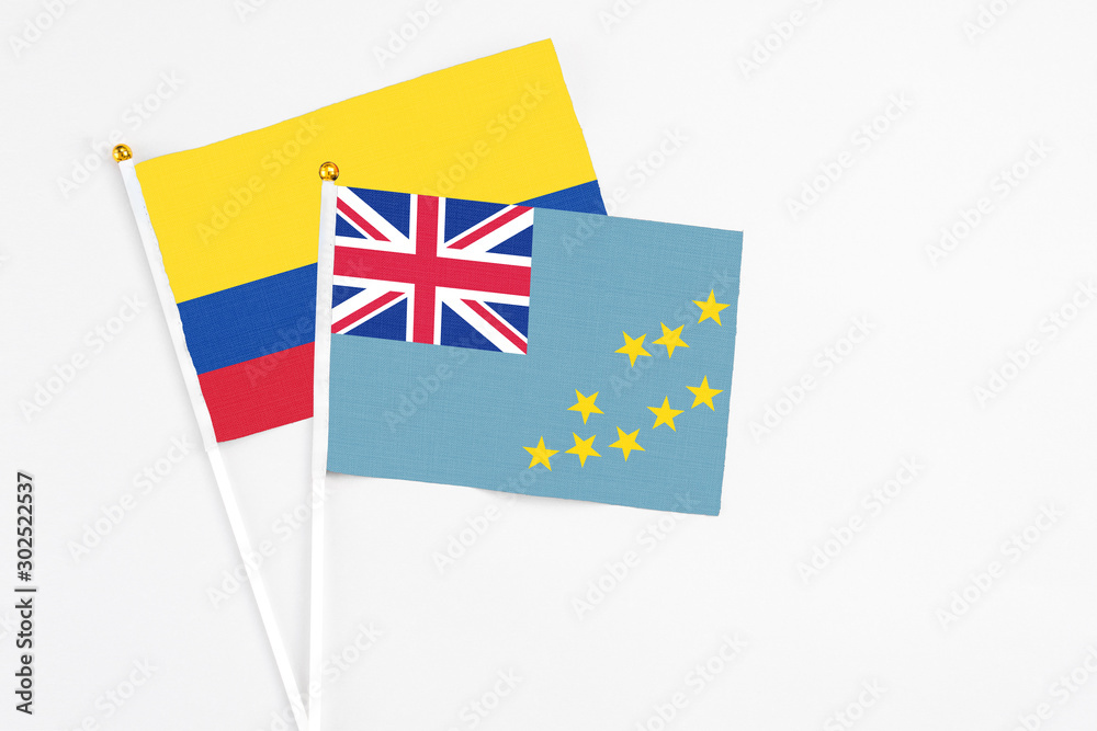 Tuvalu and Colombia stick flags on white background. High quality fabric, miniature national flag. Peaceful global concept.White floor for copy space. Tuvalu and Colombia stick flags on white background. High quality fabric, miniature national flag. Peaceful global concept.White floor for copy space.