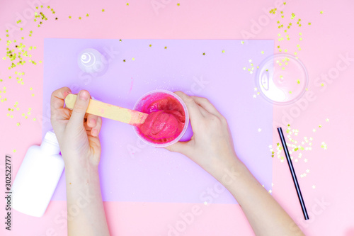 How to make slime at home. Children art project. DIY concept. Kids hands making slime toy on pink. Step by step photo instruction. Step 9 photo