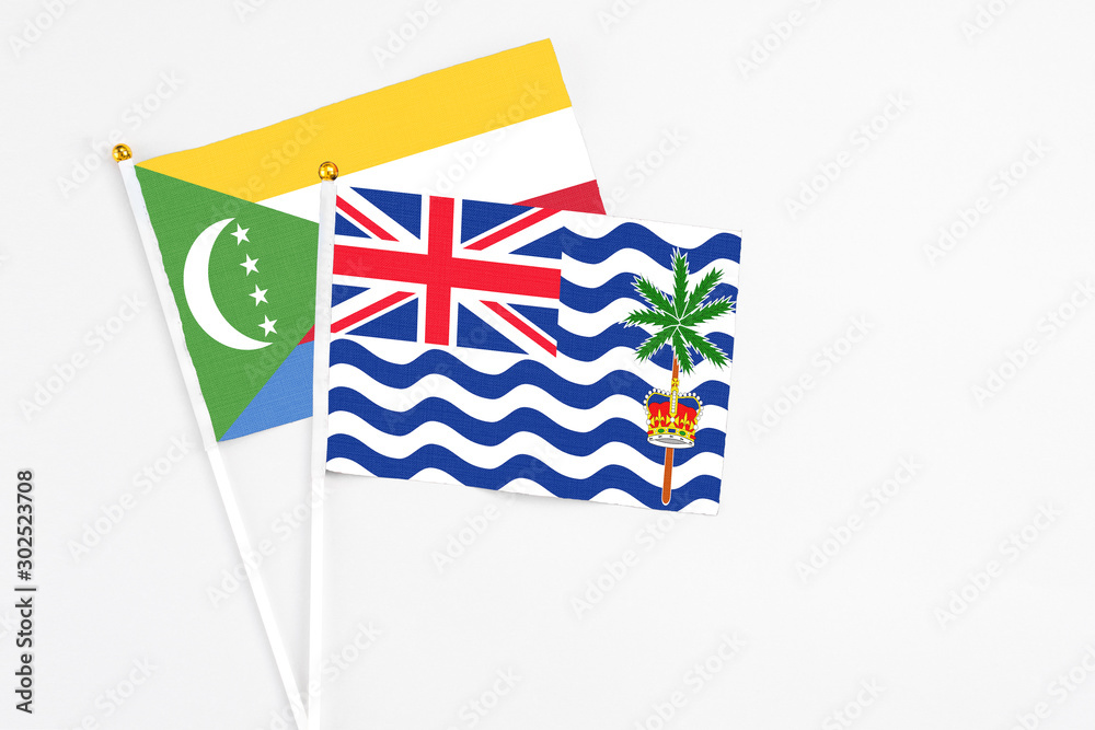 British Indian Ocean Territory and Comoros stick flags on white background. High quality fabric, miniature national flag. Peaceful global concept.White floor for copy space. British Indian Ocean Territory and Comoros stick flags on white background. High quality fabric, miniature national flag. Peaceful global concept.White floor for copy space.