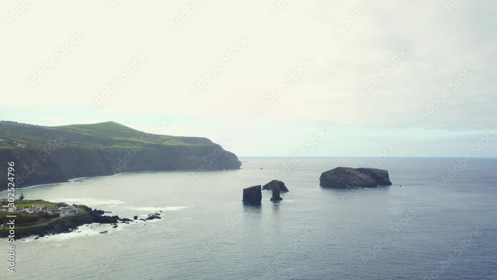 Still view over Mosteiros Bay in a Cloudy Day, with the Big Rocks on the Ocean on the Background, São Miguel Island, Azores, Portugal Still view over Mosteiros Bay in a Cloudy Day, with the Big Rocks on the Ocean on the Background, São Miguel Island, Azores, Portugal