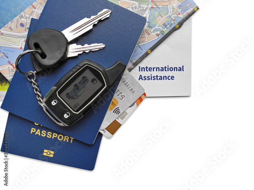 Biometric passports, bank cards, international insurance, map and car key fob alarm isolated on white background. Weekend abroad and independent car travel concept.