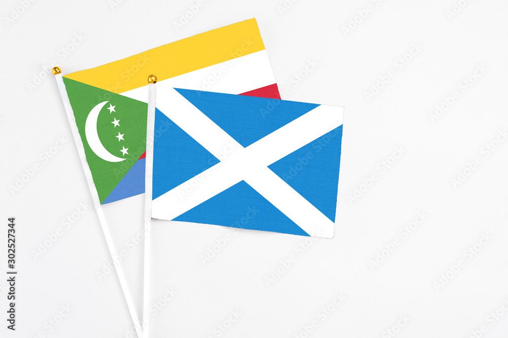 Scotland and Comoros stick flags on white background. High quality fabric, miniature national flag. Peaceful global concept.White floor for copy space. Scotland and Comoros stick flags on white background. High quality fabric, miniature national flag. Peaceful global concept.White floor for copy space.