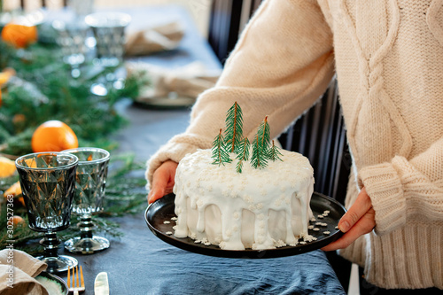 Fotografía Woman holding christmas cake with cream over a table