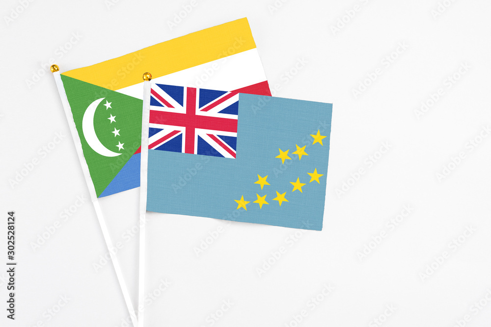 Tuvalu and Comoros stick flags on white background. High quality fabric, miniature national flag. Peaceful global concept.White floor for copy space. Tuvalu and Comoros stick flags on white background. High quality fabric, miniature national flag. Peaceful global concept.White floor for copy space.