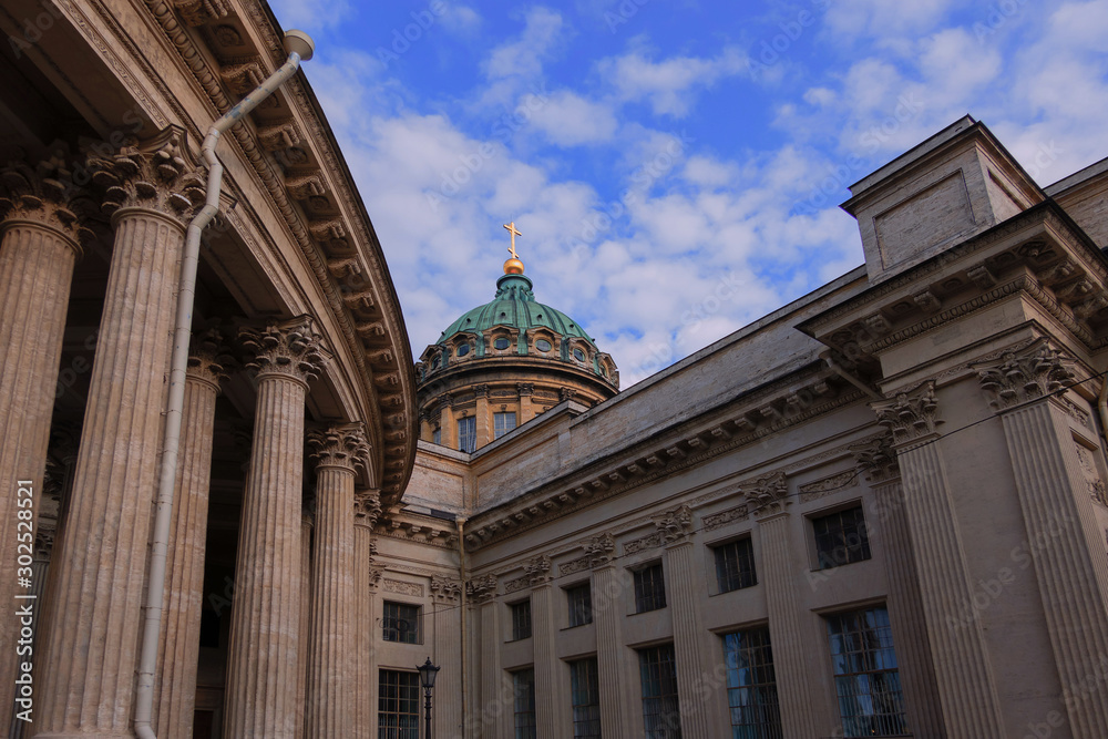 A fragment of the Kazan Cathedral. St. Petersburg. Russia. Part of the colonnade and the dome are visible. Blue sky with clouds. Background. Scenery. Details