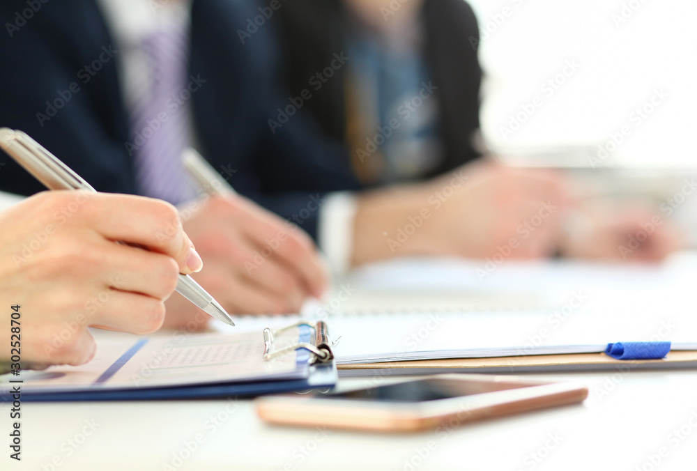 Business people in suits sitting at workplace making notes and solving problems Business people in suits sitting at workplace making notes and solving problems