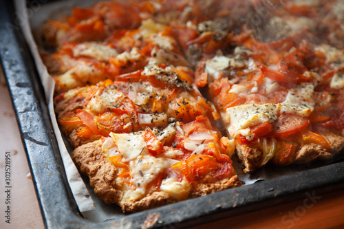 homemade pizza on a baking sheet  disposable tableware  concept zero plastic