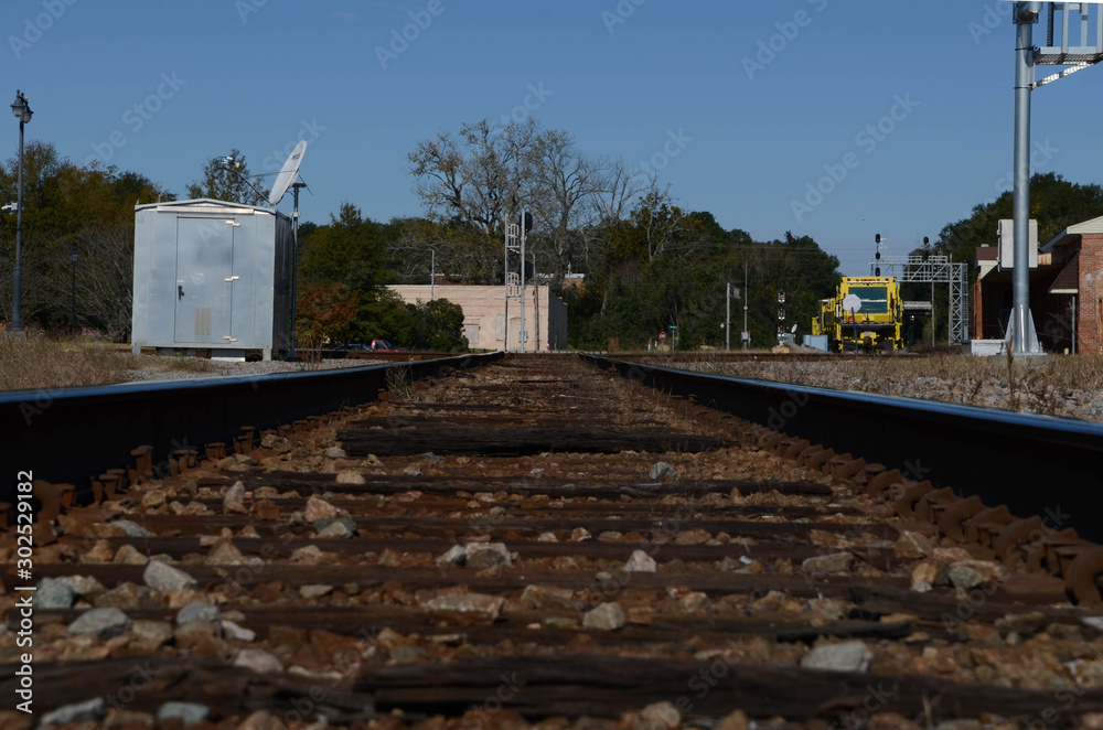 Looking down the railroad tracks. Signals and other railroad structures in the distance.