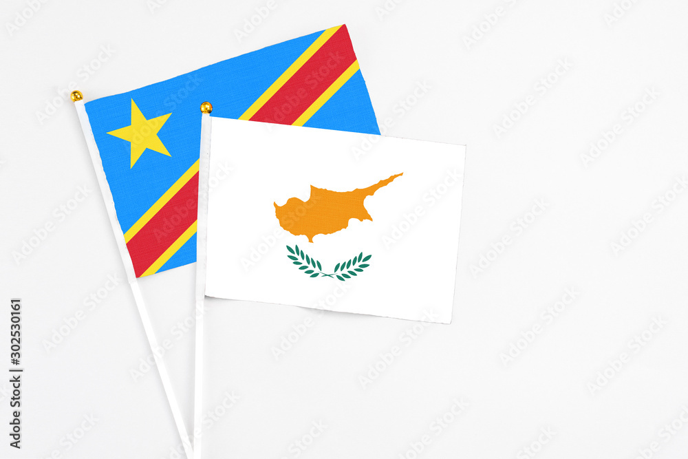 Obraz premium Cyprus and Congo stick flags on white background. High quality fabric, miniature national flag. Peaceful global concept.White floor for copy space.