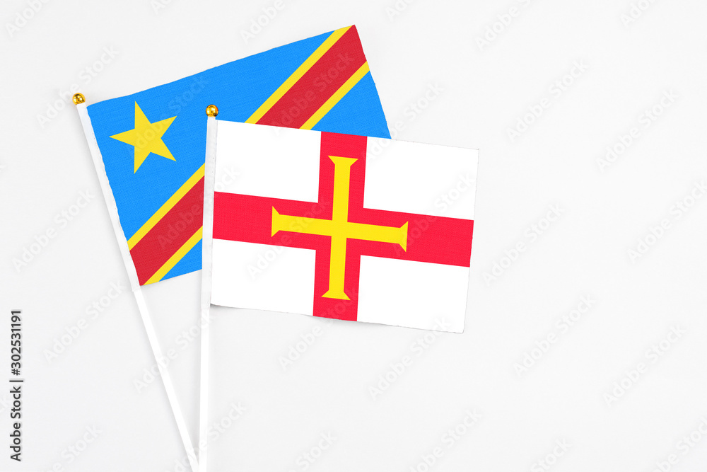 Guernsey and Congo stick flags on white background. High quality fabric, miniature national flag. Peaceful global concept.White floor for copy space.