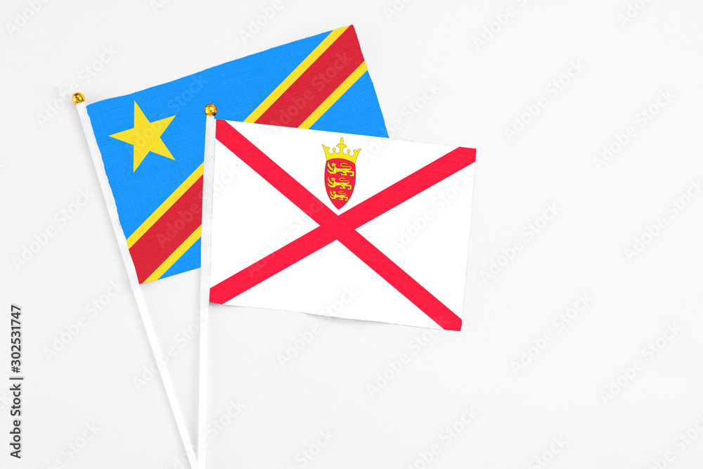 Jersey and Congo stick flags on white background. High quality fabric, miniature national flag. Peaceful global concept.White floor for copy space. Jersey and Congo stick flags on white background. High quality fabric, miniature national flag. Peaceful global concept.White floor for copy space.