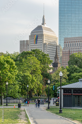 View of Boston Skyscrapers from public garden in Pride Month with rainbow flag hang outside Berkeley Building