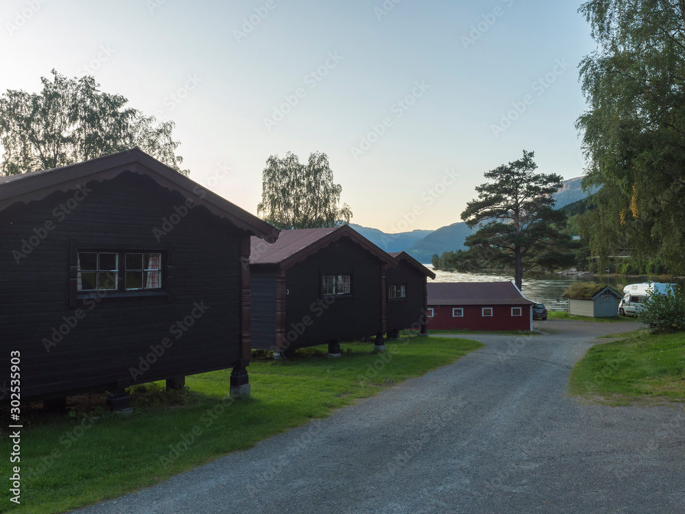View of Classical Norwegian Camping site Bravoll with traditional wooden cottages cabins at Kinsarvik by the Sorfjorden branch of Hardanger Fjord in Kinsarvik, Norway