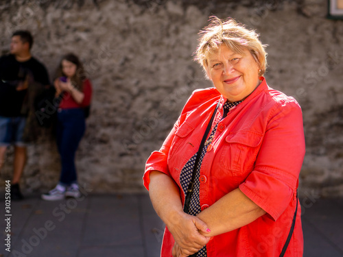 A thoughtful Mature plump woman walks the streets of the old city. Tallinn,