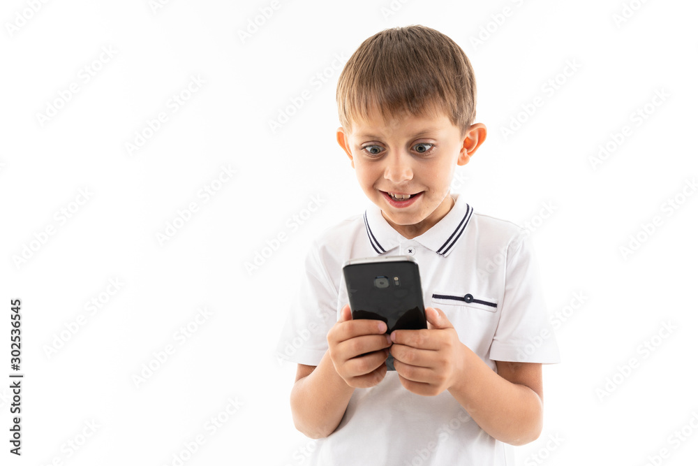 Portrait of happy caucasian boy chatting with his friends or playing phone games and smiles Portrait of happy caucasian boy chatting with his friends or playing phone games and smiles