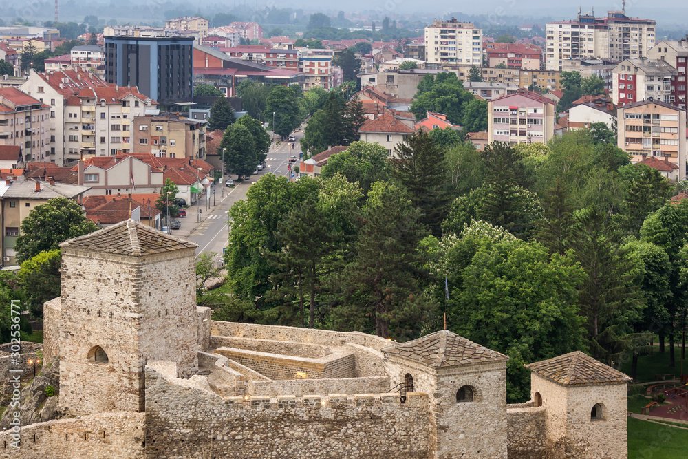 Close up view of ancient fortress Momcilov grad in Pirot, trees in a city park during spring and scenic cityscape