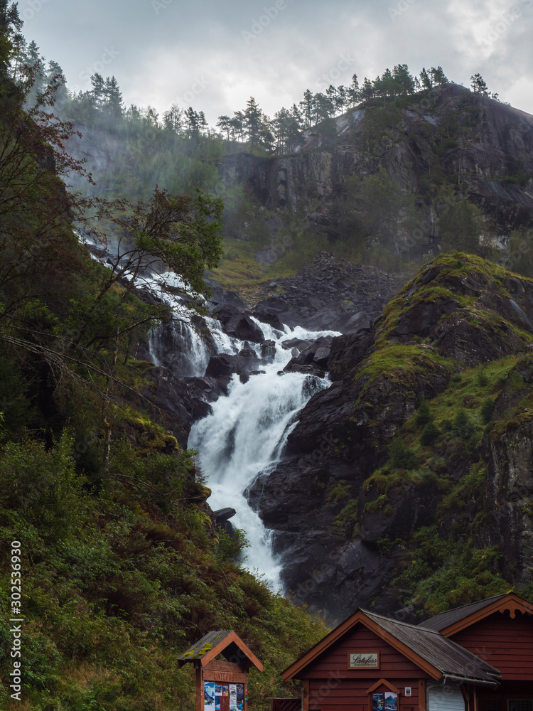 Twin waterfall Latefoss or Latefossen and souvenir shops cabins along Route 13, Odda Hordaland County in Norway.