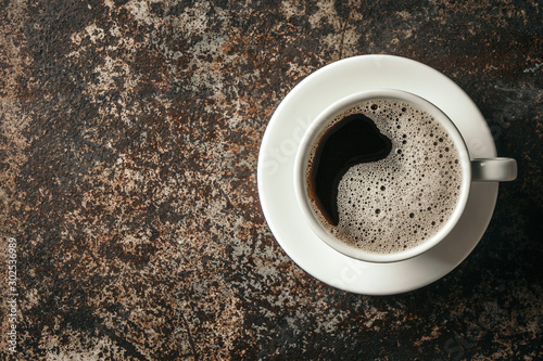 Coffee cup and coffee beans on dark stone background. .