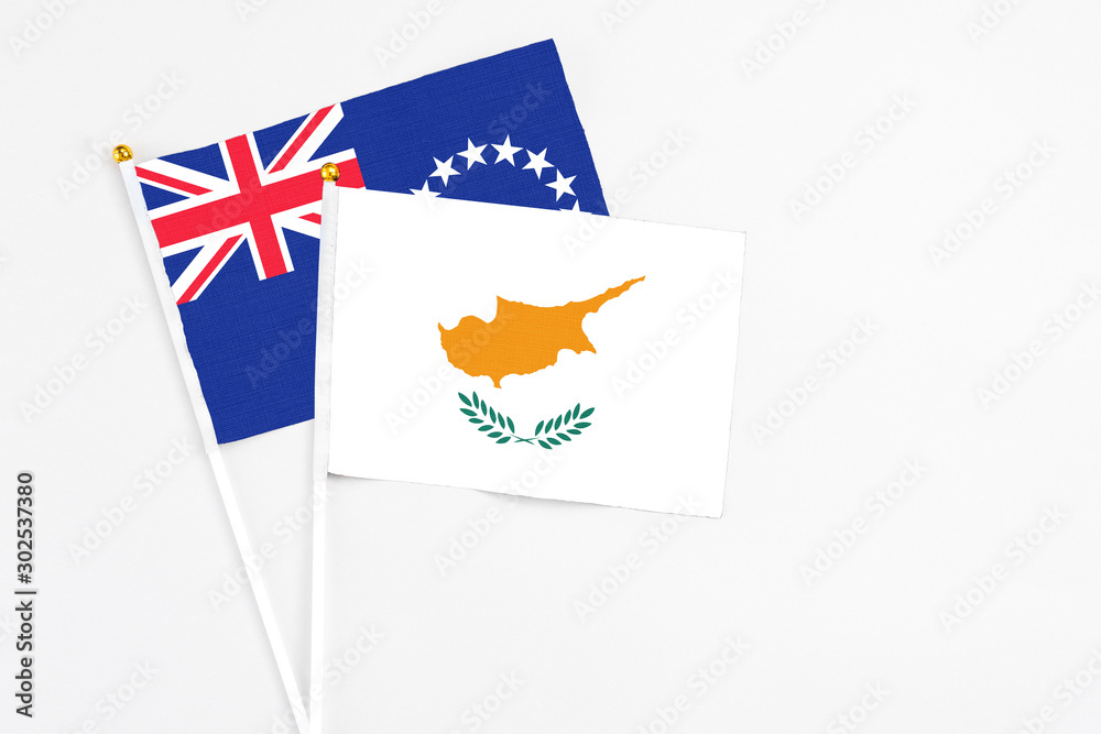 Cyprus and Cook Islands stick flags on white background. High quality fabric, miniature national flag. Peaceful global concept.White floor for copy space. Cyprus and Cook Islands stick flags on white background. High quality fabric, miniature national flag. Peaceful global concept.White floor for copy space.