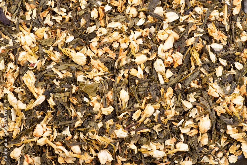  Dried green tea leaves with jasmine flowers background