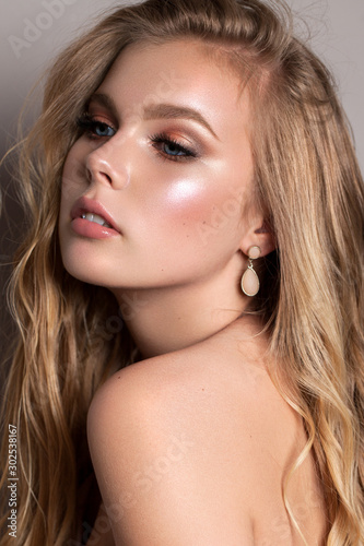 Portrait of a young beautiful model with ideal skin, professional make-up and a very beautiful natural blond hair.