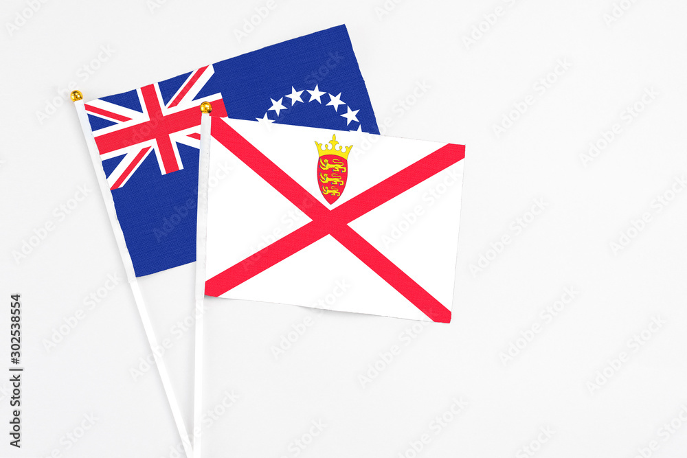 Jersey and Cook Islands stick flags on white background. High quality fabric, miniature national flag. Peaceful global concept.White floor for copy space. Jersey and Cook Islands stick flags on white background. High quality fabric, miniature national flag. Peaceful global concept.White floor for copy space.