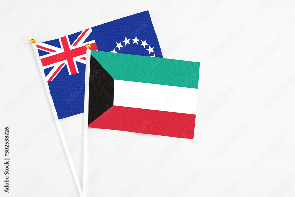 Kuwait and Cook Islands stick flags on white background. High quality fabric, miniature national flag. Peaceful global concept.White floor for copy space. Kuwait and Cook Islands stick flags on white background. High quality fabric, miniature national flag. Peaceful global concept.White floor for copy space.