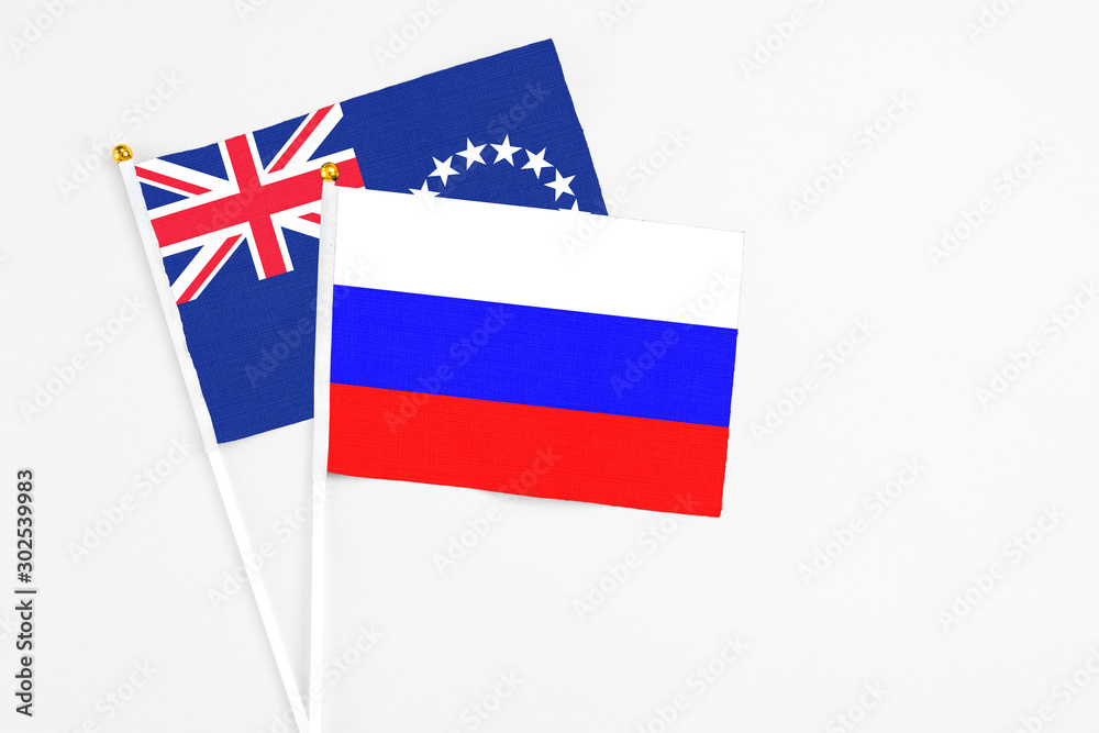 Russia and Cook Islands stick flags on white background. High quality fabric, miniature national flag. Peaceful global concept.White floor for copy space. Russia and Cook Islands stick flags on white background. High quality fabric, miniature national flag. Peaceful global concept.White floor for copy space.