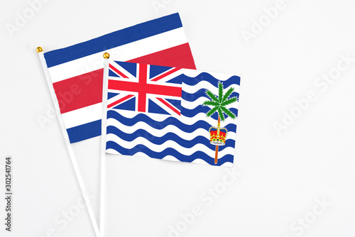 British Indian Ocean Territory and Costa Rica stick flags on white background. High quality fabric, miniature national flag. Peaceful global concept.White floor for copy space. photo