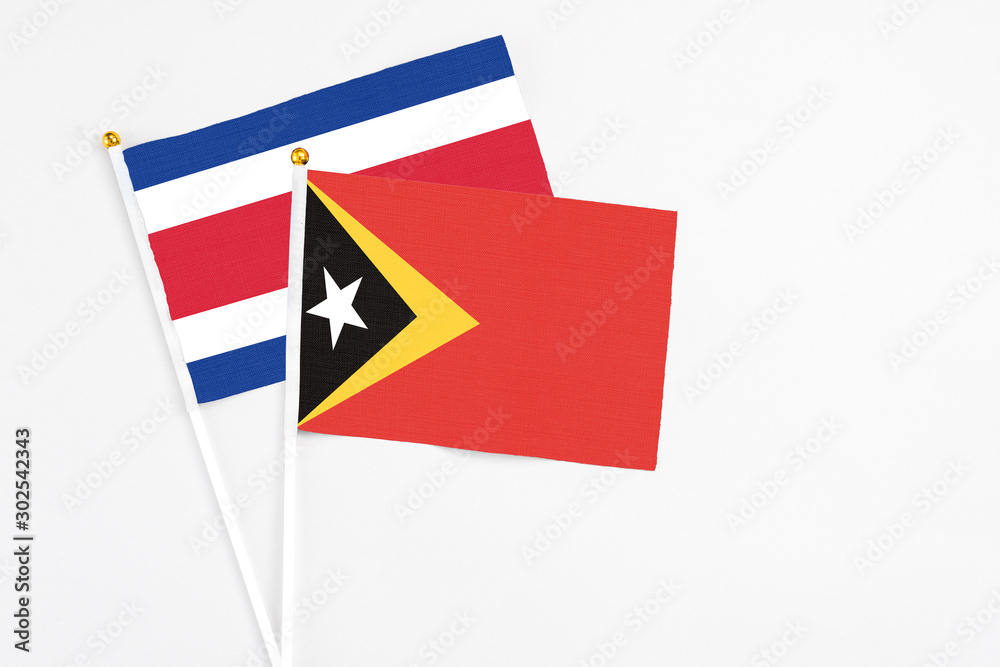 East Timor and Costa Rica stick flags on white background. High quality fabric, miniature national flag. Peaceful global concept.White floor for copy space. East Timor and Costa Rica stick flags on white background. High quality fabric, miniature national flag. Peaceful global concept.White floor for copy space.